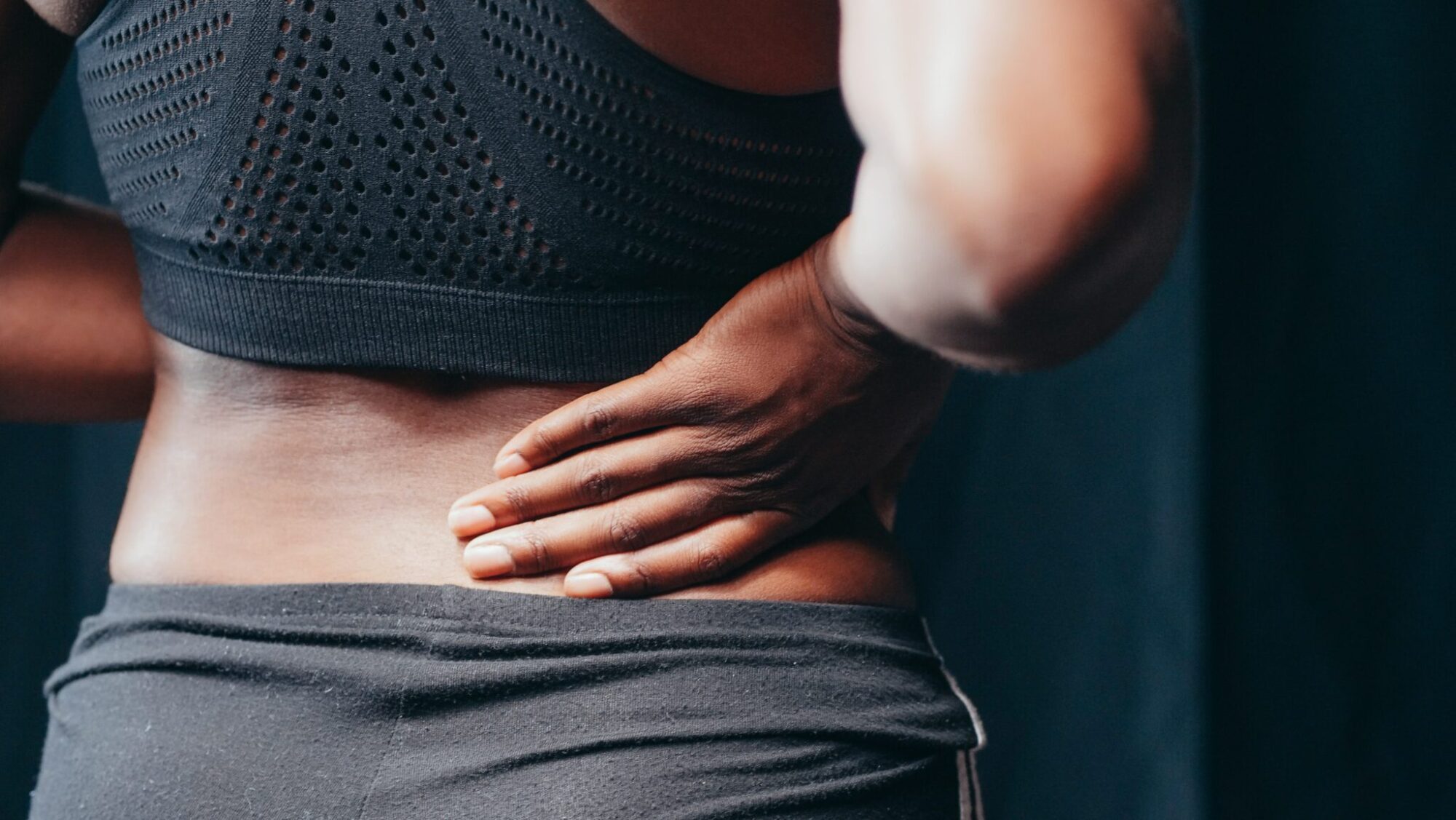 Woman holding her back in pain.