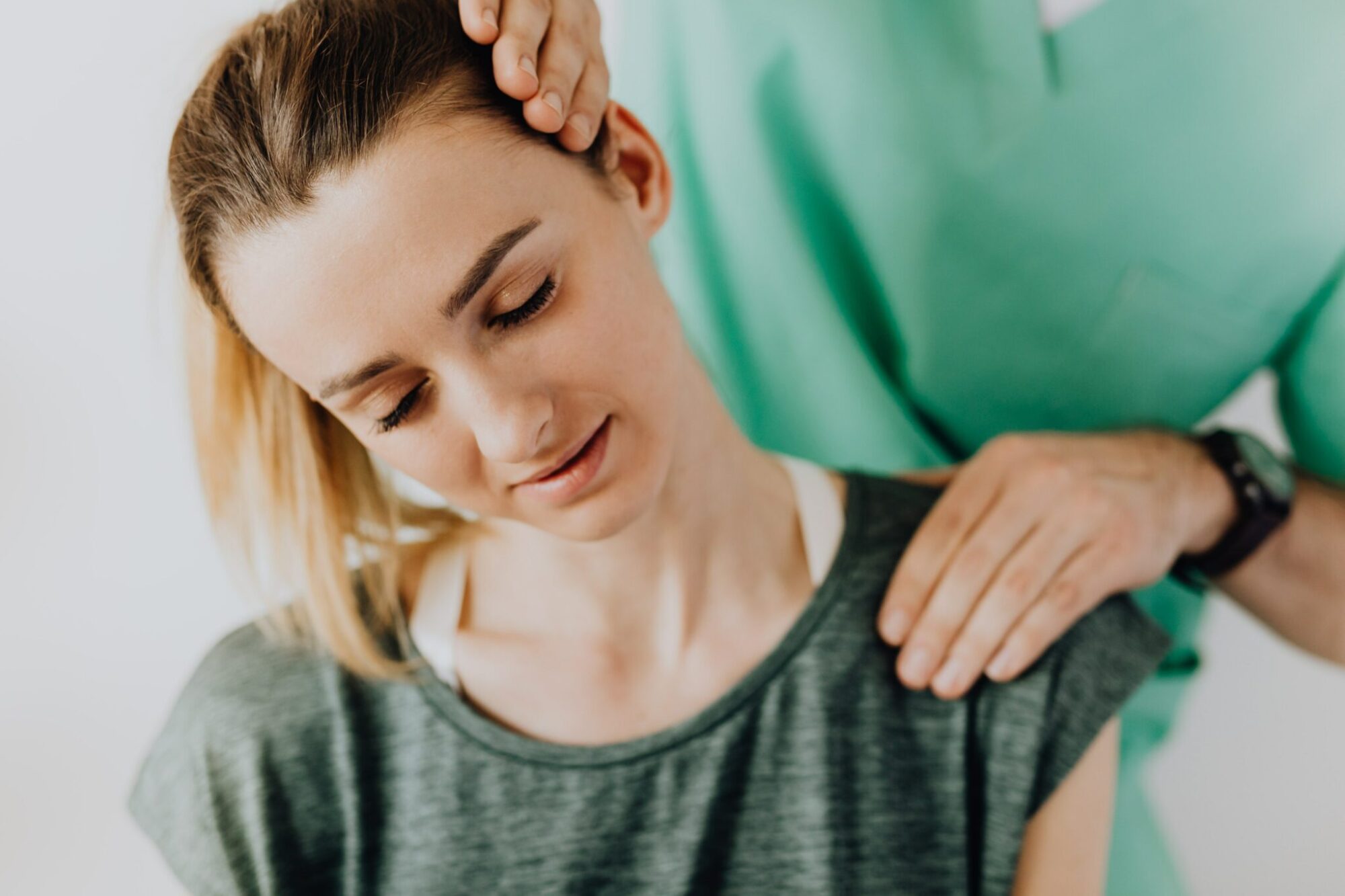 Young woman receiving neck adjustment from chiropractor